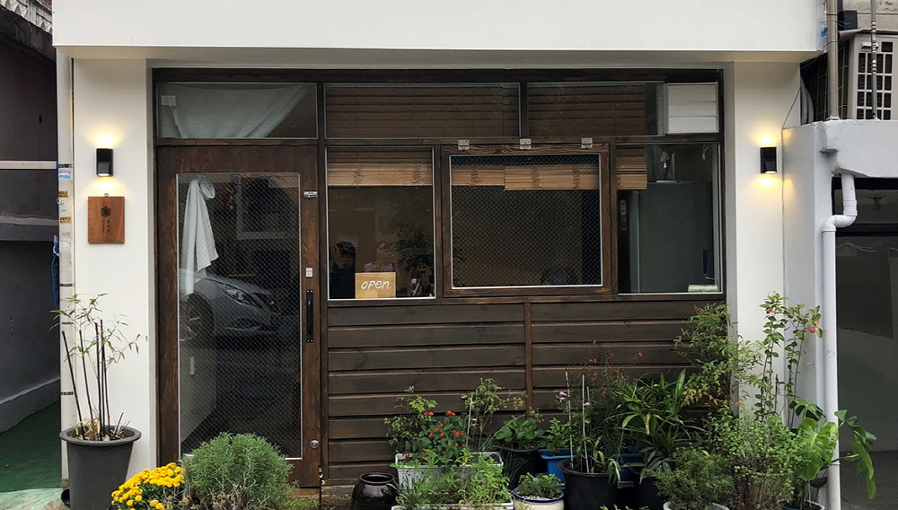 한국의 세련된 디저트 카페 테이블 위에 화려한 조각 케이크, 마카롱, 그리고 따뜻한 커피가 정갈하게 놓여 있는 항공샷