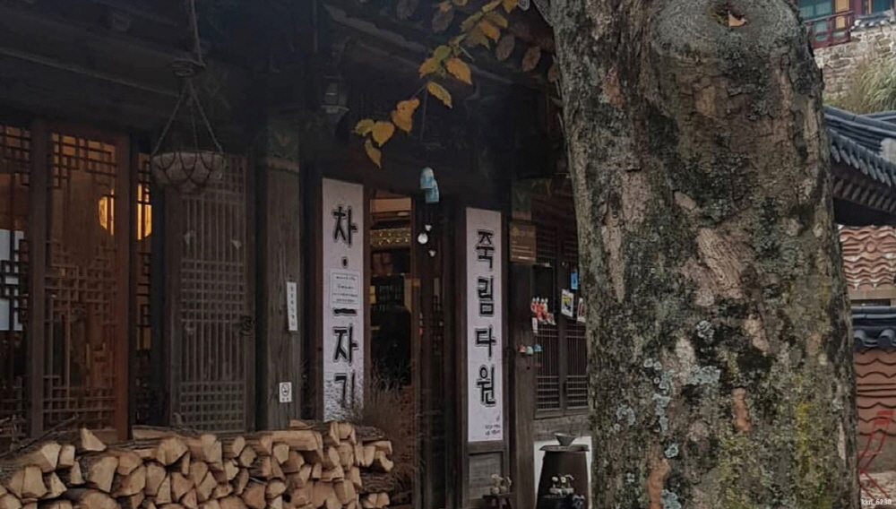 한국 카페 테이블 위에 놓인 신선한 딸기가 층층이 쌓인 하얀 생크림 케이크와 아이스 아메리카노 한 잔