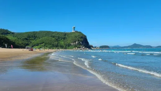 한국 전통 시장 골목에 위치한 소박한 식당 내부와 숯불 위에 구워지는 굴